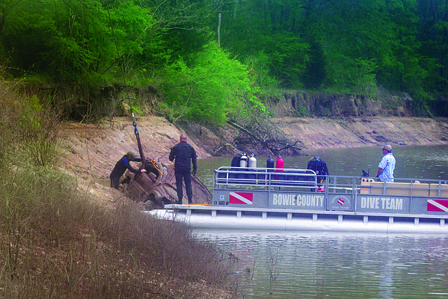 Crews pull an SUV from the Sulphur River on Monday afternoon at the edge of Bowie and Cass counties. The 2000 GMC Yukon plunged into the Wright Patman Lake spillway Sunday evening with a man and a woman inside. Lucia Mendoza, 29, was rescued Sunday evening, but a search is ongoing for the unidentified man. 