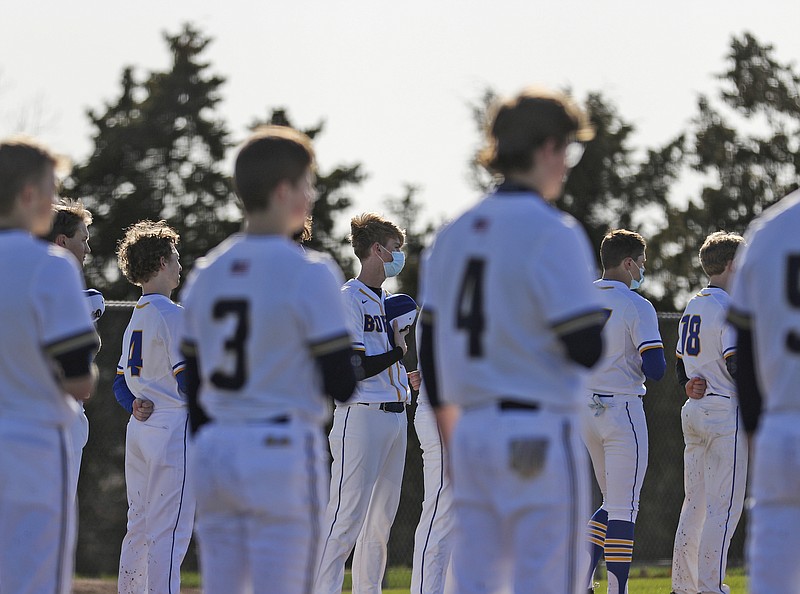 Helias and Borgia baseball players stand on the baselines prior to last Monday's game at the American Legion Post 5 Sports Complex.