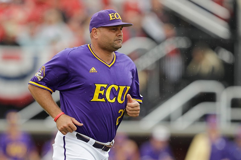 FILE - In this June 7, 2019, file photo, East Carolina head coach Cliff Godwin runs to question a call during the fourth inning in Game 1 of an NCAA college baseball super regional tournament game against Louisville, in Louisville, Ky. East Carolina continues to show it's one of the most complete teams in college baseball last week, going 5-0 with a four-game sweep of Cincinnati in its American Athletic Conference opening series. (AP Photo/Darron Cummings, File)