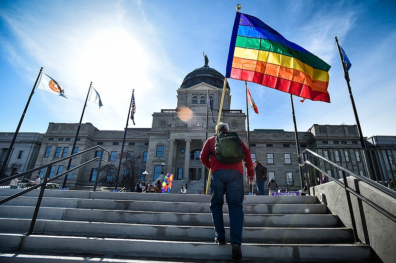 FILE - In this March 15, 2021, file photo demonstrators gather on the steps of the Montana State Capitol protesting anti-LGBTQ+ legislation in Helena, Mont. The Montana Senate advanced Tuesday, March 30, 2021, a bill that would ban transgender athletes from participating in school and college sports according to the gender with which they identify, but amended it to be voided if the federal government withholds federal funding from the state due to the measure. (Thom Bridge/Independent Record via AP, File)