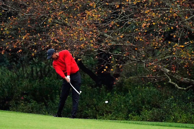 Tiger Woods hits on the second fairway during the final round of the Masters golf tournament in Augusta, Ga., in this Sunday, Nov. 15, 2020, file photo. Gone are the autumn hues of gold, orange and red in the trees, the brown leaves mixed in with the pine straw on the ground. Augusta National is blazing with pink and red and purple azaleas, accented by the white blooms of dogwood. Postponed last year because of the COVID-19 pandemic, the Masters is back to being that annual rite of spring. (AP Photo/Matt Slocum, File)