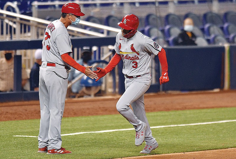 Dylan Carlson is congratulated by Cardinals third base coach Pop Warner after hitting a home run in the ninth inning of Tuesday night's game against the Marlins in Miami.