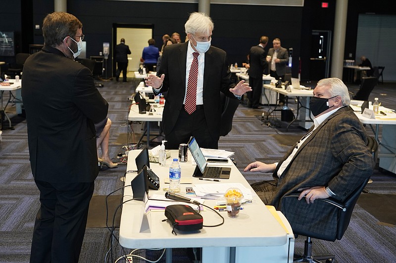 Virginia State Senate Majority Leader, Sen. Richard Saslaw, center, along with Sen. John Cosgrove, R-Chesapeake, left, talk with new Sen. Travis Hackworth, R-Tazewell, during the Senate reconvene session at the Science Museum of Virginia in Richmond, Va., Wednesday, April 7, 2021. Hackworth replaced Sen. Chafin who died earlier this year. (AP Photo/Steve Helber)