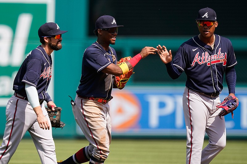 Atlanta Braves outfielders Ender Inciarte, left, Ronald Acuna Jr., and Marcell Ozuna celebrate after the first baseball game of a doubleheader at Nationals Park, Wednesday, April 7, 2021, in Washington. The Braves won the first game 7-6. (AP Photo/Alex Brandon)