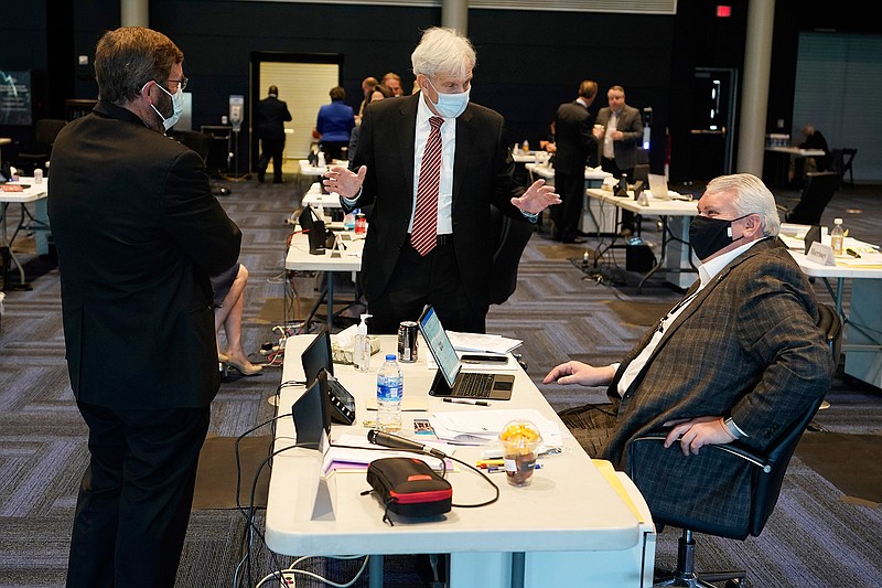 Virginia State Senate Majority Leader, Sen. Richard Saslaw, center, along with Sen. John Cosgrove, R-Chesapeake, left, talk with new Sen. Travis Hackworth, R-Tazewell, during the Senate reconvene session at the Science Museum of Virginia in Richmond, Va., Wednesday, April 7, 2021. Hackworth replaced Sen. Chafin who died earlier this year. (AP Photo/Steve Helber)