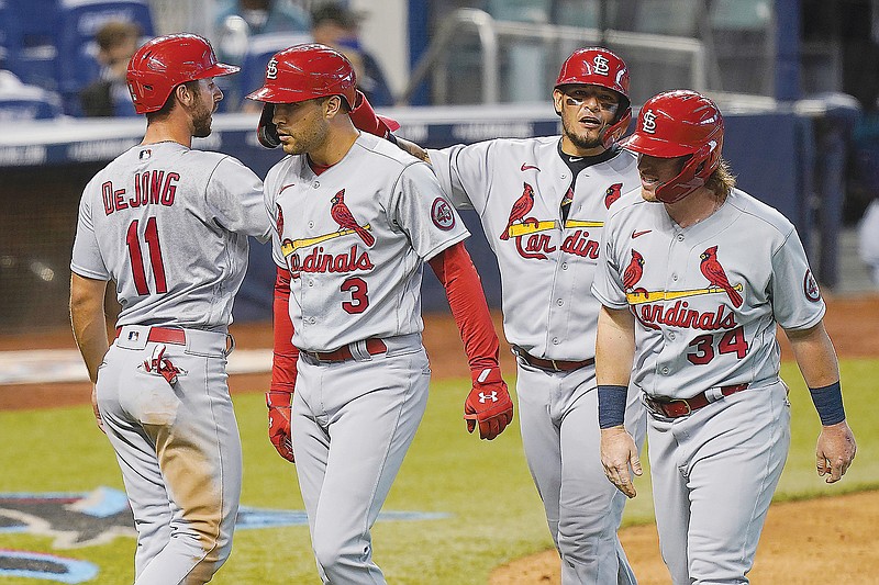 Dylan Carlson (3) is congratulated by Cardinal teammates (from left) Paul DeJong, Yadier Molina and John Nogowski after Carlson hit a grand slam in the ninth inning of Wednesday's game against the Marlins in Miami.