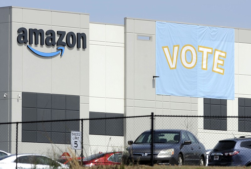 FILE - In this Tuesday, March 30, 2021 file photo, a banner encouraging workers to vote in labor balloting is shown at an Amazon warehouse in Bessemer, Ala.  Amazon workers voted against forming a union, Friday, April 9,  in Alabama, handing the online retail giant a decisive victory and cutting off a path that labor activists had hoped would lead to similar efforts throughout the company and beyond.  (AP Photo/Jay Reeves, File)