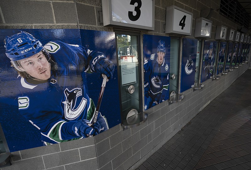 Canucks players are pictured Thursday outside the closed box office of Rogers Arena in downtown Vancouver, British Columbia.