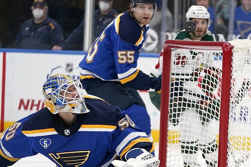 Blues goaltender Jordan Binnington watches as a puck flies harmlessly over the net during the third period of Friday night's game against the Wild in St. Louis.