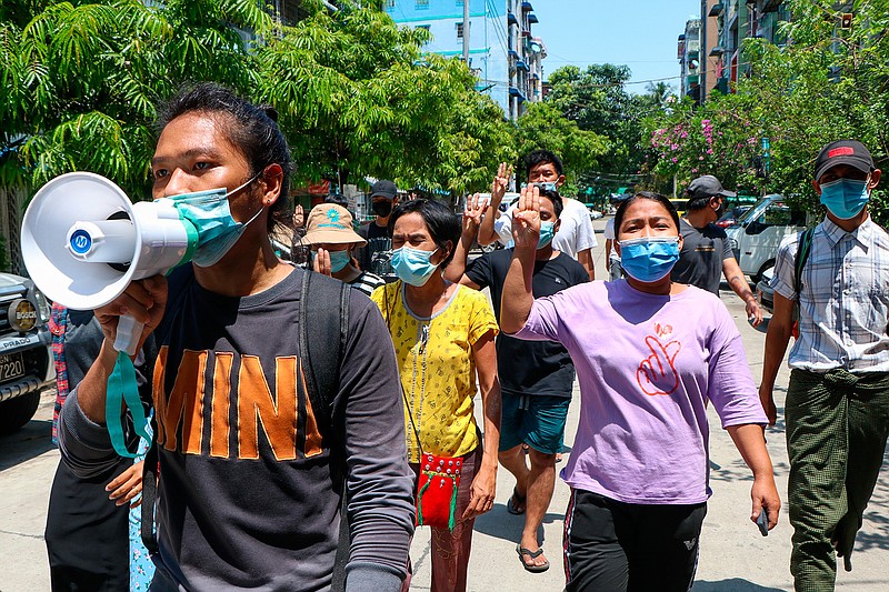 Young demonstrators flash the three-fingered symbol of resistance as they march in Yangon, Myanmar, Saturday, April 10, 2021. Security forces in Myanmar cracked down heavily again on anti-coup protesters Friday even as the military downplayed reports of state violence.(AP Photo)