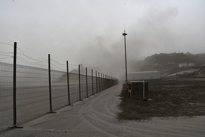 A road is blanketed in volcanic ash at the international airport in Kingstown, on the eastern Caribbean island of St. Vincent, Saturday, April 10, 2021 due to the eruption of La Soufriere volcano. (AP Photo/Orvil Samuel)