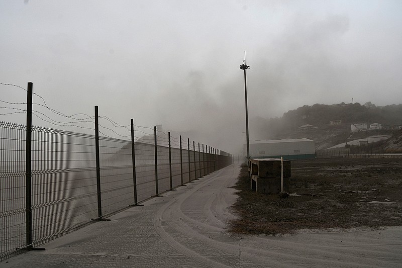 A road is blanketed in volcanic ash at the international airport in Kingstown, on the eastern Caribbean island of St. Vincent, Saturday, April 10, 2021 due to the eruption of La Soufriere volcano. (AP Photo/Orvil Samuel)