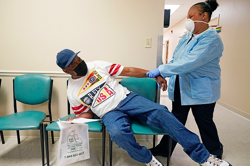 In this April 7, 2021, file photo, Wilbert Marshall, 71, left, pretends to be scared of receiving the COVID-19 vaccine from a nurse at the Aaron E. Henry Community Health Service Center in Clarksdale, Miss. Marshall, who was among a group of seniors from the Rev. S.L.A. Jones Activity Center for the Elderly who received their vaccinations, said he wanted the vaccination in order to stay safe and be able to visit with family without the constant fear of the virus. (AP Photo/Rogelio V. Solis)
