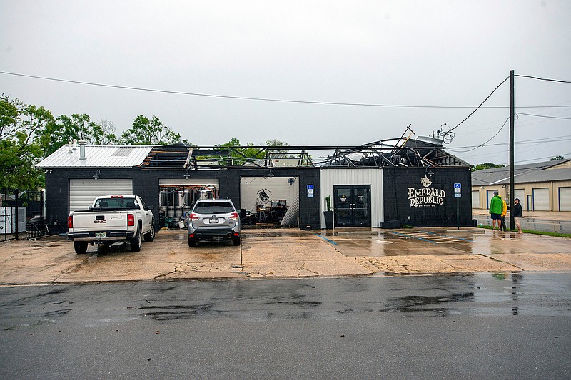 Employees assess the damage after the storm that came through Pensacola, Fla., and blew the roof off of Emerald Republic Brewing on Saturday, April 10, 2021.  (John Blackie/Pensacola News Journal via AP)