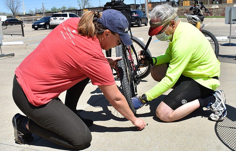 Gerry Tritz/News Tribune
At right, Max Earl helps Shelda Sternberg inflate her bike tires before Sunday's 10-mile community bike ride.