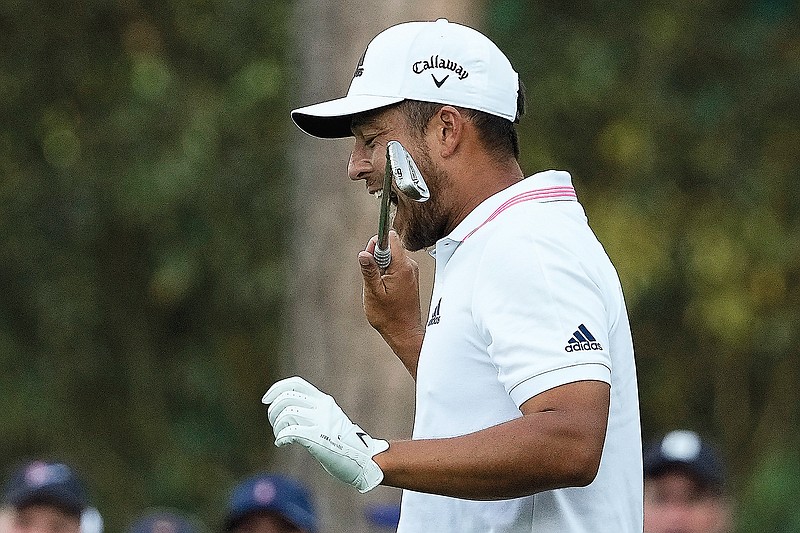 Xander Schauffele bites his club after hitting a second shot after his first ended up in the water on the 16th hole Sunday in the final round of the Masters in Augusta, Ga.