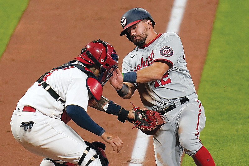Cardinals catcher Yadier Molina tagas out Kyle Schwarber of the Nationals at the plate to end the top of the eighth inning in Monday night's game at Busch Stadium.