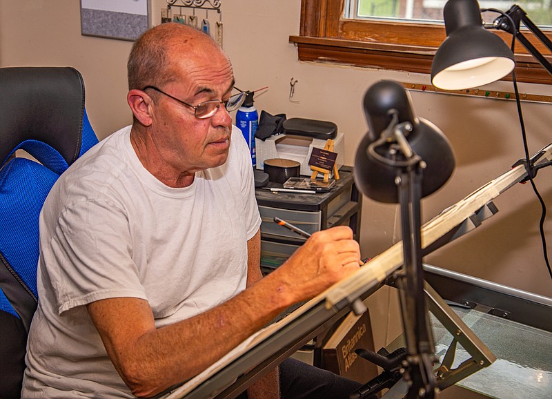 Paul Johnson works on his latest drawing in his home studio.  (Ken Barnes/News Tribune)