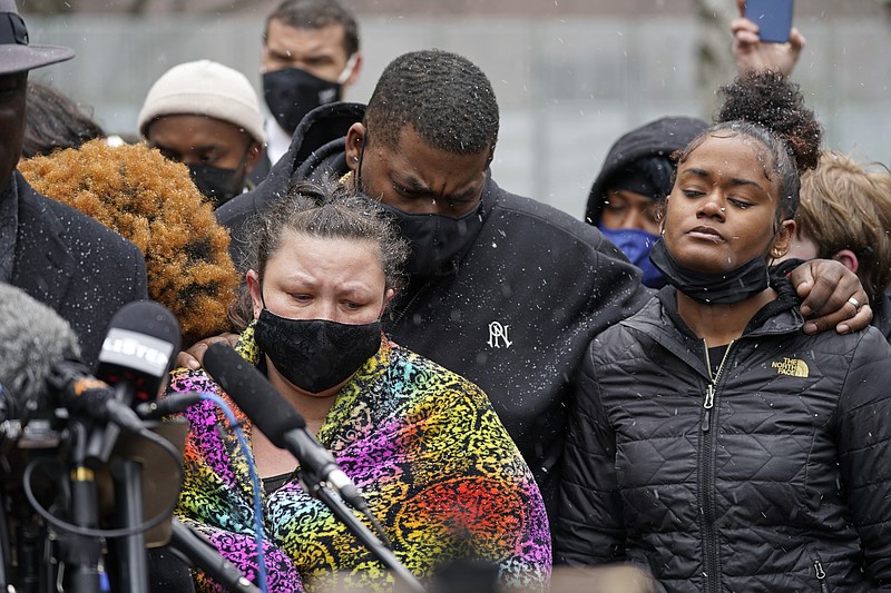 Katie Wright, left, the mother of Daunte Wright, and other family and friends gather during a news conference Tuesday, April 13, 2021, in Minneapolis as family attorney Ben Crump speaks. Daunte Wright, 20, was shot and killed by police Sunday after a traffic stop in Brooklyn Center, Minn. (AP Photo/Jim Mone)
