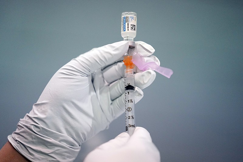 FILE - In this March 26, 2021, file photo, a member of the Philadelphia Fire Department prepares a dose of the Johnson & Johnson COVID-19 vaccine at a vaccination site setup at a Salvation Army location in Philadelphia. U.S. health regulators on Tuesday, April 13, is recommending a “pause” in using the vaccine to investigate reports of potentially dangerous blood clots. (AP Photo/Matt Rourke, File)