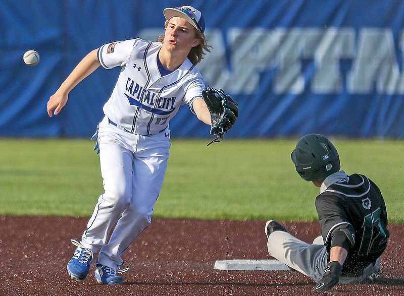 Capital City shortstop Brock Miles tries to reach out and catch the ball to tag out Rock Bridge runner Hudson Borgmeyer during the first inning of Tuesday's game at Capital City High School.