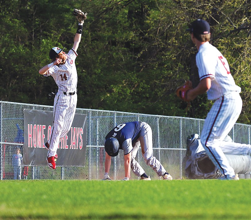 Jefferson City's Brayden Whittle leaps to catch a throw as Battle's Sean Keene ducks on his way to third base during a game Tuesday at Vivion Field.
