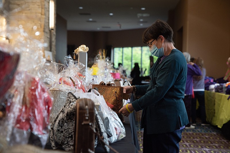 Sharon Boos, resident of Seguin, Texas, which is 30 miles east of San Antonio, looks at bags up for silent auction Wednesday afternoon during the Texas State Convention for the Catholic Daughters of the Americas.