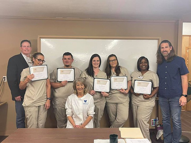 From left are United Way of Greater Texarkana CEO Mark Bledsoe, with certified nursing assistant graduates Diane Auer, Kody Scott, April Martinez, Tiffany Dalton and Ronita Miller, and Mission TXK Executive Director Cody Howard. Instructor Liz Gunn is seated in front. (Photo courtesy of Molly Riley)
