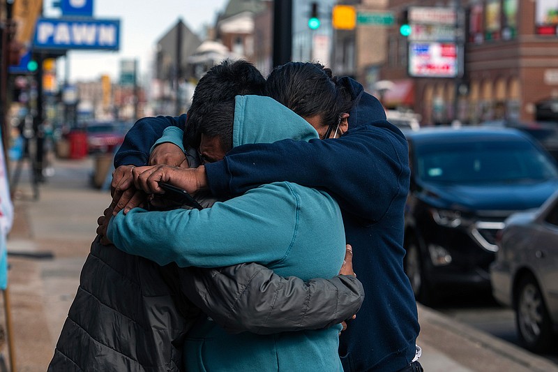 Baltazar Enriquez, Kristian Armendariz, and Enrique Enriquez embrace one another, after the body camera footage of Chicago police killing Adam Toledo was released, Thursday, April 15, 2021 in Chicago. A 13-year-old Chicago boy appears to have dropped a handgun and begun raising his hands less than a second before a police officer shot and killed him last month, footage released Thursday under community pressure shows. (Tyler LaRiviere/Chicago Sun-Times via AP)