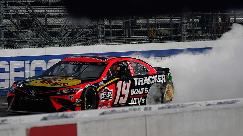 Martin Truex Jr. (19) does a burnout as he celebrates after winning a NASCAR Cup Series auto race at Martinsville Speedway in Martinsville, Va., Sunday, April 11, 2021. (AP Photo/Steve Helber)