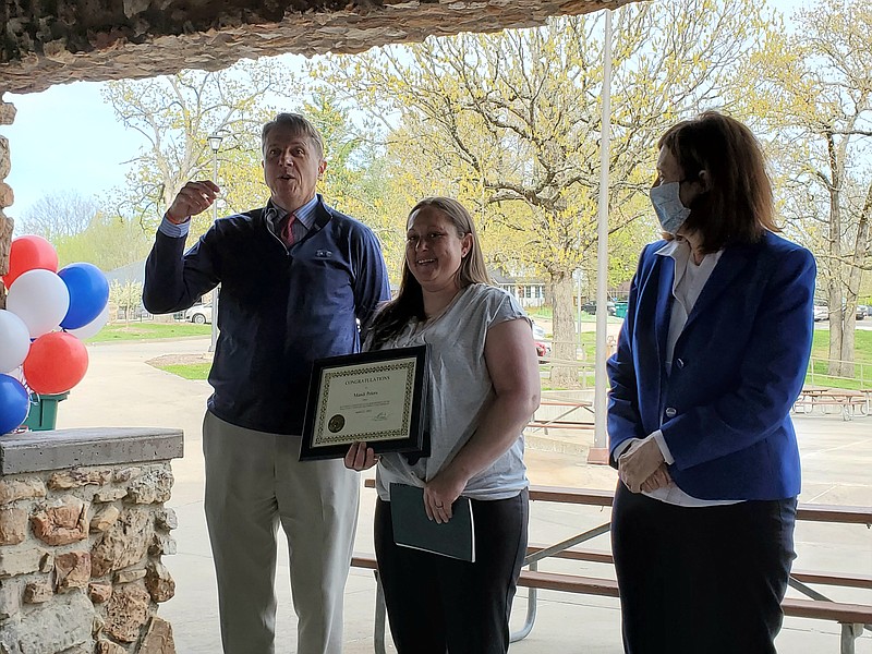 <p>Jeff Haldiman/News Tribune</p><p>Cole County Circuit Judge Cotton Walker congratulates Mandi Peters on her graduation from Veterans Treatment Court during a celebration Thursday night at McClung Park. Judge Pat Joyce, who began the treatment programs in the circuit courts, is at right. Peters was one of nine people honored for completing treatment programs offered by the courts.</p>