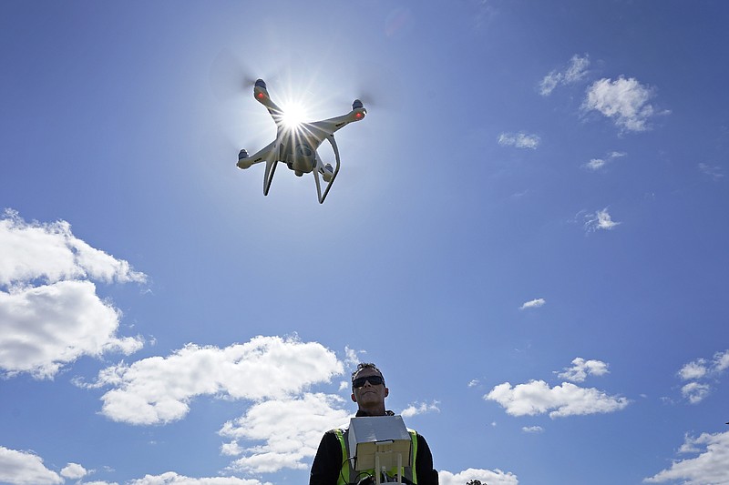 Michael Jones operates his drone in Goldsboro, N.C., on Friday, April 2, 2021. When Jones started shooting drone photos and videos for realtors, his clients wanted more: Images with property lines on them. But after two years of steady business, Jones was slapped by the state of North Carolina in 2018 with an order that grounded his drone. The Board of Examiners for Engineers and Surveyors said he faced criminal prosecution for surveying without a license. Jones sued in March 2021, accusing the board of violating his First Amendment rights. (AP Photo/Gerry Broome)