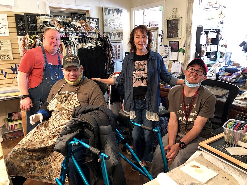 Barb Reid — the co-founder of Re-Made For a Purpose in Fulton — poses in the store with, from left, workers Joey Garrard, Jordan Stewart and Thomas Branch last Thursday. The resale boutique and upcycled creations shop — a nonprofit business — opened in November 2015 and employs adults with disabilities.