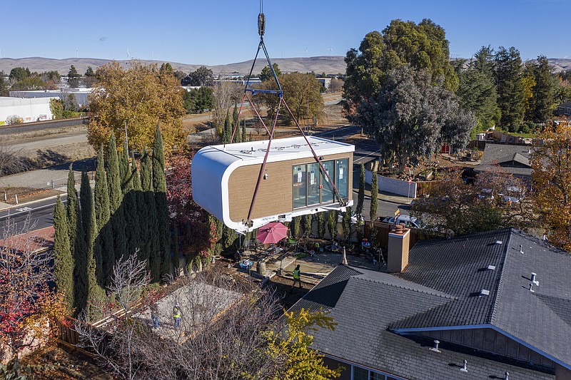 This photo provided by Mighty Buildings shows a 3D-printed housing module being delivered. Most of the modules built by Mighty Buildings are assembled in the factory, transported by truck to the owner’s property, then put into place using a crane. (Courtesy of Mighty Buildings via AP)