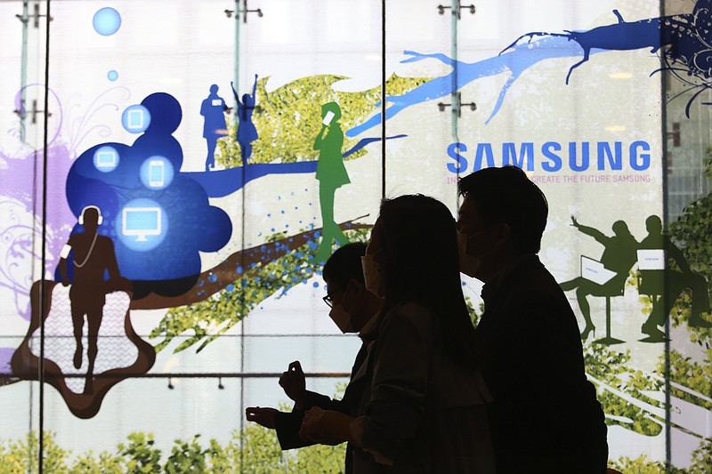 People pass by Samsung Electronics' shop in Seoul, South Korea, Wednesday, April 28, 2021. Samsung's founding family will donate tens of thousands of rare artworks, including Picassos and Dalis, and give hundreds of millions of dollars to medical research to help them pay a massive inheritance tax following last year's death of chairman Lee Kun-Hee. (AP Photo/Ahn Young-joon)