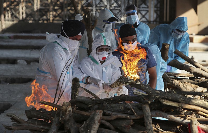 Family members of a person who died due to COVID-19 light the funeral pyre at a crematorium in Jammu, India, Monday, April 26, 2021. (AP Photo/Channi Anand)