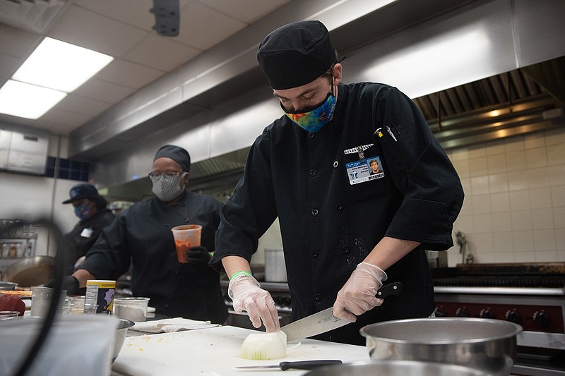 Nathan Whittington, a second-semester culinary student at Texarkana College, chops an onion during the first round of the program's "Chopped" competition Thursday afternoon. Following the first round and second round, the winners from each competed against each other.
