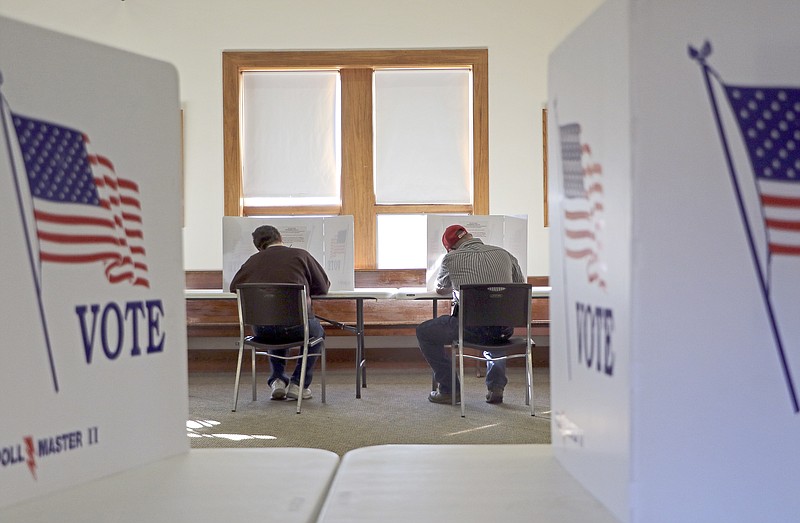 Two voters sit and fill out their ballots during a 2020 election at Trinity Lutheran Church in Russellville. (Liv Paggiarino/News Tribune photo)