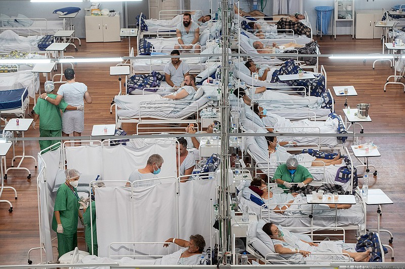 In this March 4, 2021 file photo, COVID-19 patients rest in a field hospital built inside a sports coliseum in Santo Andre, on the outskirts of Sao Paulo, Brazil. The country has stepped back from the edge — at least for now  as burial and hospital services no longer risk collapse. It has ceased to be the virus global epicenter, as its death toll ebbed. (AP Photo/Andre Penner, File)