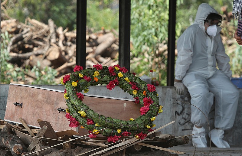 A wreath lies on the coffin of a COVID-19 victim before his cremation in Jammu, India, Friday, April 30, 2021.  Indian scientists appealed to Prime Minister Narendra Modi to publicly release virus data that would allow them to save lives as coronavirus cases climbed again Friday, prompting the army to open its hospitals in a desperate bid to control a massive humanitarian crisis. (AP Photo/Channi Anand)