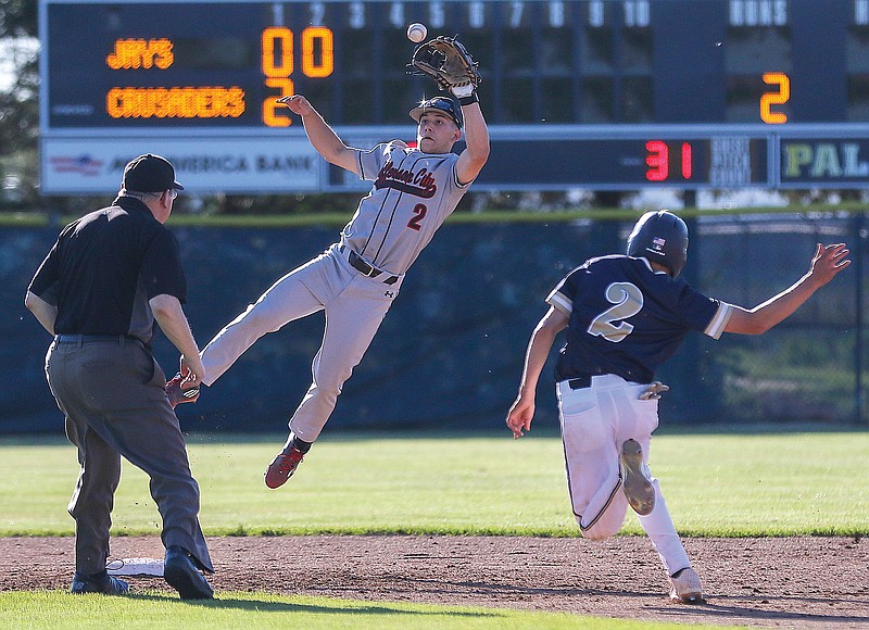 Jefferson City second baseman Connor Earleywine jumps up to catch a ball as Alex Loethen of Helias sprints toward second base during Friday's game at the American Legion Post 5 Sports Complex.