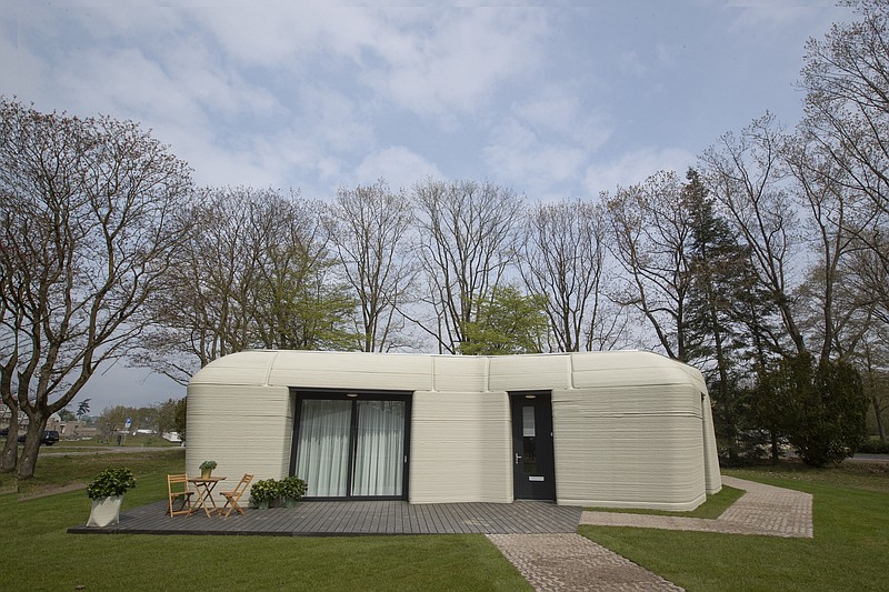 Exterior view showing the printer layers of the 3D-printed 94-square meters (1,011-square feet) two-bedroom bungalow resembling a boulder with windows in Eindhoven, Netherlands, Friday, April 30, 2021. The fluid, curving lines of its gray walls look natural. But they are actually at the cutting edge of housing construction in the Netherlands and around the world. They were 3D printed at a nearby factory. (AP Photo/Peter Dejong)