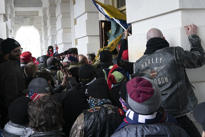 FILE - In this Jan. 6, 2021 file photo insurrectionists loyal to President Donald Trump try to open a door of the U.S. Capitol as they riot in Washington. With riot cases flooding into Washington’s federal court, the Justice Department is under pressure to quickly resolve the least serious cases. (AP Photo/Jose Luis Magana, File)