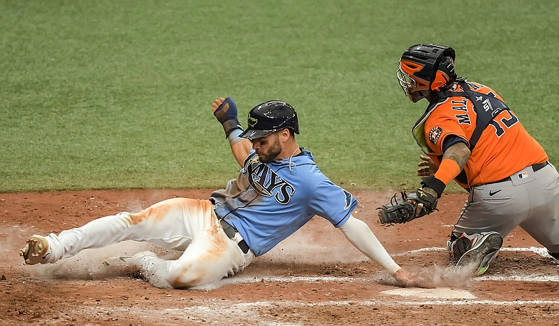 Tampa Bay Rays' Kevin Kiermaier, left, slides past Houston Astros catcher Martin Maldonado, right, to score on Rays' Willy Adames' ground ball to first during the sixth inning of a baseball game Sunday, May 2, 2021, in St. Petersburg, Fla. (AP Photo/Steve Nesius)