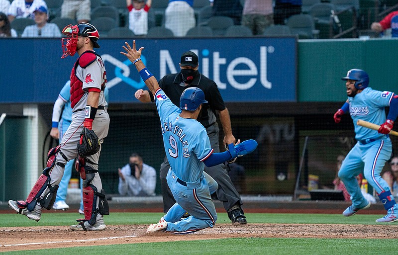 Texas Rangers' Isiah Kiner-Falefa (9) scores on a go-ahead RBI-single by teammate Brock Holt as home plate umpire Brian O'Nora and Boston Red Sox catcher Kevin Plawecki look on while Rangers' Jose Trevino, right, celebrates during the eighth inning of a baseball game Sunday, May 2, 2021, in Arlington, Texas. (AP Photo/Jeffrey McWhorter)