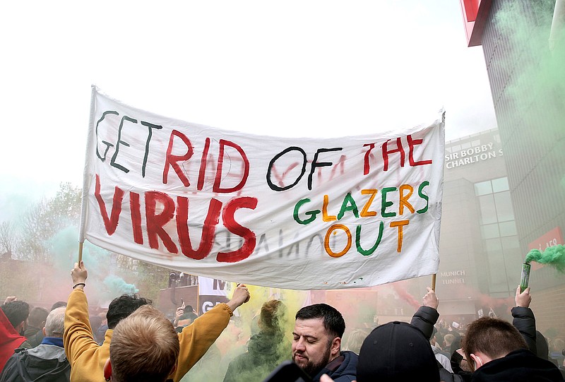 Fans holds up a banner as they protest against the Glazer family, owners of Manchester United, before their Premier League match against Liverpool at Old Trafford, Manchester, England, Sunday, May 2, 2021. (Barrington Coombs/PA via AP)