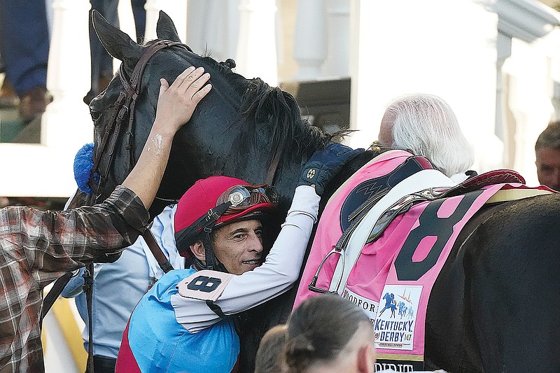 Jockey John Velazquez hugs Medina Spirit on Saturday after winning the 147th running of the Kentucky Derby at Churchill Downs in Louisville, Ky.