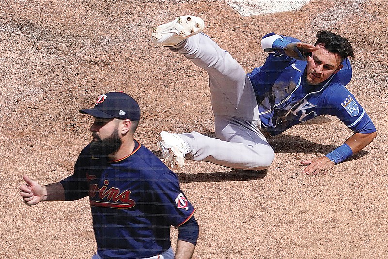 Nicky Lopez of the Royals tumbles after scoring a run behind Twins pitcher Matt Shoemaker during the fourth inning of Saturday's game in Minneapolis.