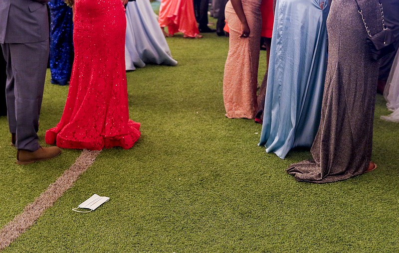 In this News Tribune file photo, a mask lies on the ground amid dozens of sparkling dresses during JCHS's prom on Saturday, May 1, 2021, at Adkins Stadium.