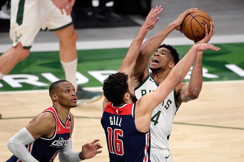 Milwaukee Bucks' Giannis Antetokounmpo drives to the basket against Washington Wizards' Anthony Gill and Russell Westbrook during the second half of an NBA basketball game Wednesday, May 5, 2021, in Milwaukee. (AP Photo/Aaron Gash)